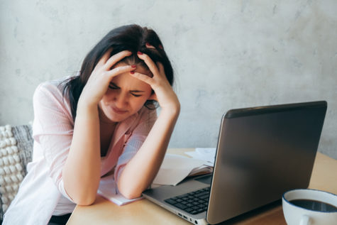 Student suffering from a headache due to staring at a computer too long.